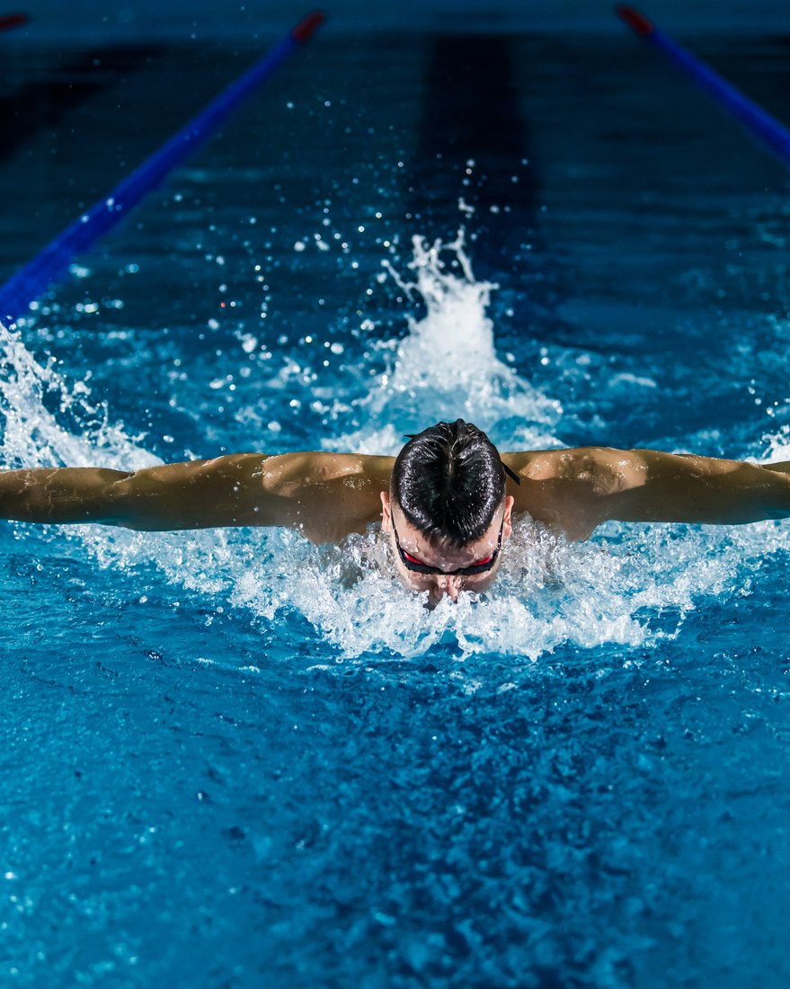 Swimmer doing butterfly stroke in a competition pool